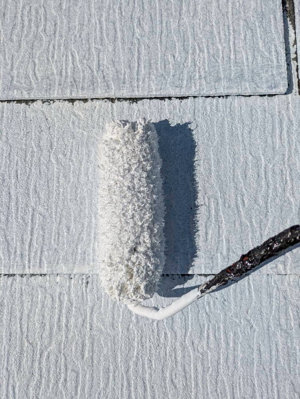 白い下塗り材を塗装中